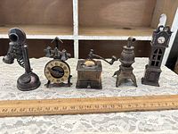 Group shot of all five miniature metal pencil sharpeners beside ruler