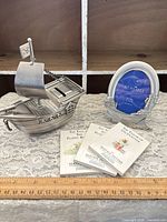 Group shot showing pewter pirate ship bank, Seagull frame and three mini books with ruler for scale