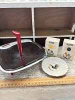 Full lot: tray with red handle, two shakers, saucer, ruler for scale