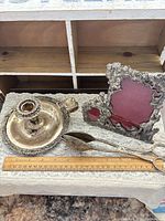 Lot overview showing chamberstick, wick trimmer and frame with ruler for scale