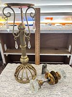 Overall view showing brass candlestick, glass door knob set, ruler for scale
