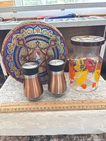 Group shot showing decorative tin, salt & pepper shakers, glass jar