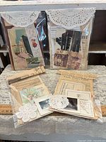 four clear packs of assorted vintage ephemera displayed on lace table