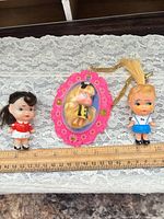 Front view of all three dolls with ruler for scale