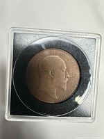 Obverse of 1906 penny in plastic holder showing bust of Edward VII