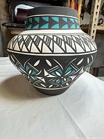 Side view of vase showing geometric turquoise, black and white design