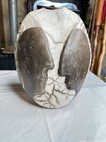 Front view of oval raku vase showing black and white crackle glaze and relief design