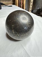 Full view of black resin sphere showing gold veining pattern