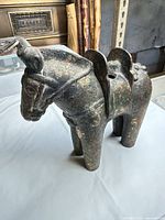 Left front three-quarter view of entire bronze horse figurine showing patina and overall form