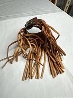 Overall view of leather cuff with fringe spread