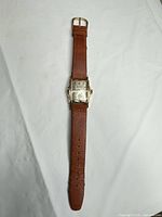Full view of wristwatch with brown leather strap laid flat
