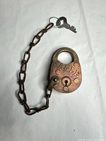 Full view of brass padlock with chain and key
