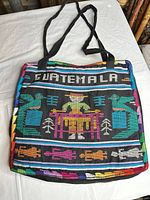 Front of black woven tote bag showing GUATEMALA text and colorful motif