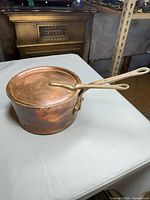 Side view showing saucepan, handle, lid