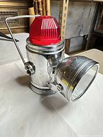 Front angled view showing chrome body, front lamp, red beacon lens