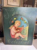 Full view of painted wood panel showing cherub, text and overall design