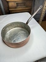 Oblique view of skillet showing copper exterior, stainless interior and handle