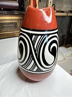 Front view showing red-orange glaze and black/white geometric band