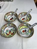 Four famille rose porcelain bowls each with matching rooster motif spoon