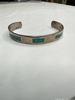 Front view showing turquoise inlay segments on sterling cuff