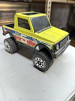 Side angle of yellow Tonka truck body showing decals and wheels