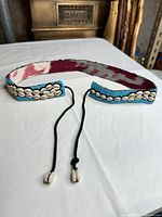 Full belt laid flat showing bead and shell decoration with cord ties