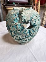 Front three-quarter view of turquoise textured vase showing open cavity and overall form