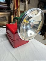 Front angled view showing red battery box, green lamp head, chrome reflector