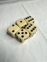 Five cream Bakelite dice viewed from top angle