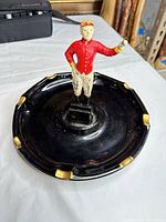 Top view of black ceramic ashtray with figurine