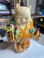 Front three-quarter view of full figurine showing glaze colors and animal motifs