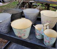 Group shot of all eight metal buckets on cart