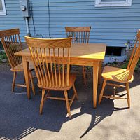 Table and four chairs arranged outdoors