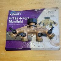 Front view of Orbit brass 4-port manifold and packaging