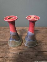 Front view of two multicolour ceramic candlestick holders