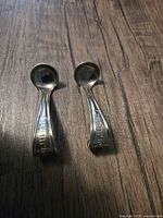 Two CreamTop spoons front view on wood surface