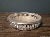 angled side view showing silver-plated rim slots and pressed glass bowl