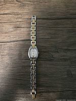 Full view of Fossil two-tone wrist watch laid flat