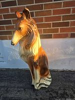 Front-side view of large collie piggy bank showing molded fur details and paint wear