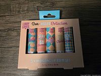Front of box displaying five lip balm tubes and flavour graphics