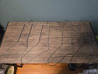 Four silver wire sock-shaped hangers laid flat on table