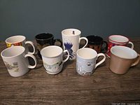 Front view of all nine mugs showing designs and colors