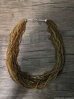 Full view of necklace laid flat showing multi strands and clasp