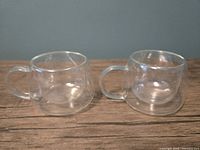 Two clear double-walled glass mugs on tabletop