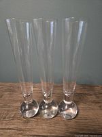 Front view of three clear glass bud vases standing side by side