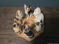 overhead view showing six cat figurines around central candle recess