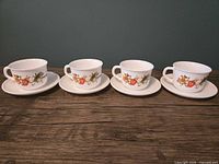 Front view of four teacup and saucer sets