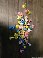 scattered view of multicolor plastic floral candle bases on wood surface