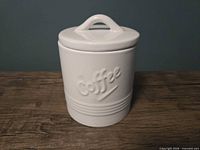 Front view of white ceramic coffee canister with lid attached