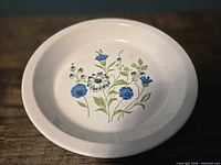 Top view of white ceramic pie plate showing blue floral design and rolled rim